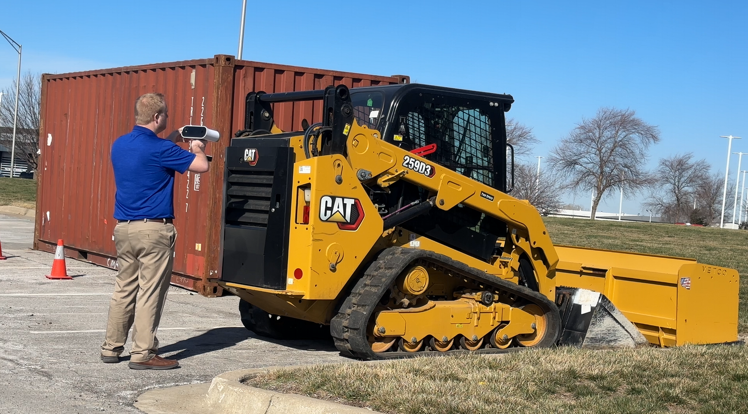 3DMakerWorld technician 3D scanning a CAT compact track loader on-site with a handheld scanner